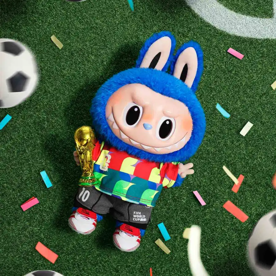 Labubu FIFA Catch the Win 2026 với thân xanh, áo phối nhiều màu và mô hình cúp bóng đá